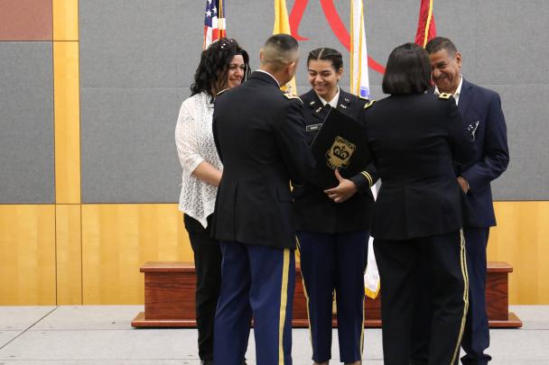 Second Lieutenant Lucia Miano on stage with her parents