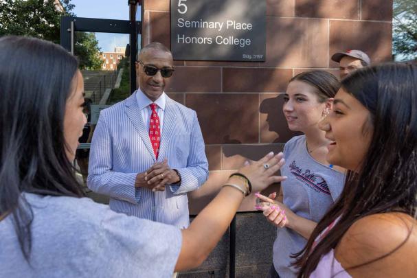 Rutgers President William F. Tate IV listens to students outside the Honors College during move-in day.