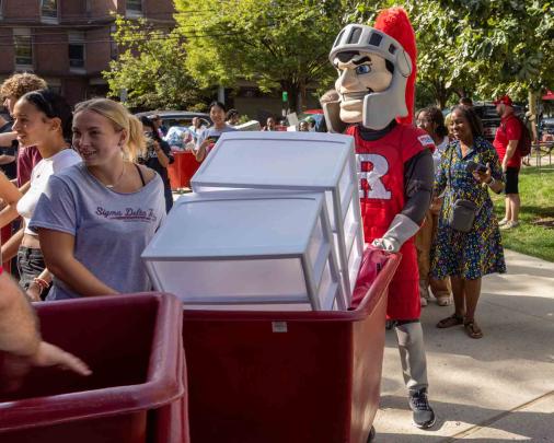 Sir Henry helps a student during move-in day outside of the Honors College.