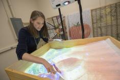 Rutgers alum Angela Johnsen (SEBS '15) works in the the sand table in Blake Hall